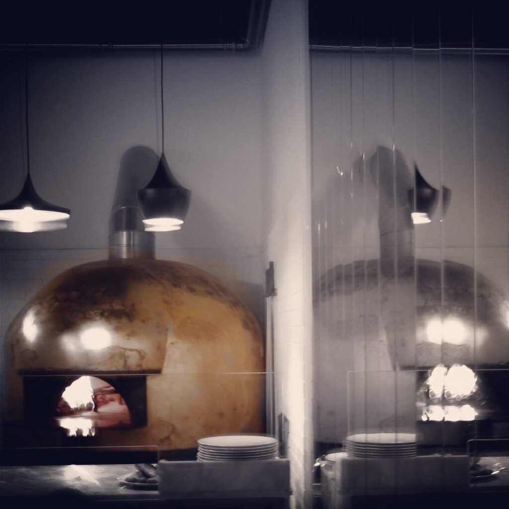 Warm pendant lights and the Una Pizza oven